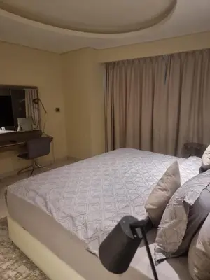 a bedroom with a bed with a desk and a window at 1 Bedroom Tower D Paramount Apt in Dubai