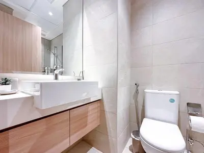 a bathroom with a white toilet and a sink at Cozy Studio in Azizi Riviera with Balcony in Meydan City in Dubai
