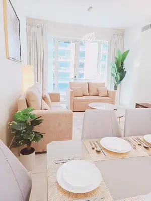 a living room with white furniture and white tables at Stylish Marina View Apartment With Private Marina Walk Access in Dubai