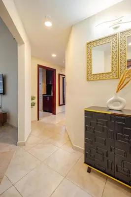 a living room with a mirror and a dresser at Stylish Marina View Apartment With Private Marina Walk Access in Dubai