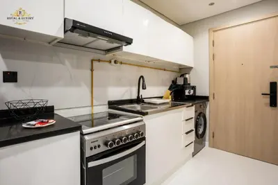 a kitchen with a stove and a sink at Modern Studio at The Crescent Tower B, IMPZ - In the heart of Dubai in Dubai