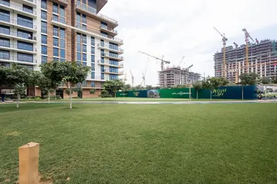 a park in the middle of a city with tall buildings at Luxe 1BR in Citywalk with Pool Balcony & More in Dubai