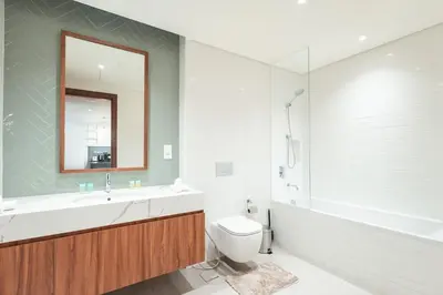 a bathroom with a sink and a toilet and a tub at Luxe 1BR in Citywalk with Pool Balcony & More in Dubai