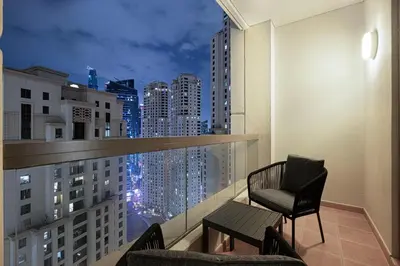 a balcony with two chairs and a view of a city at FIRST CLASS 2BR Breathtaking Beach Views in Dubai