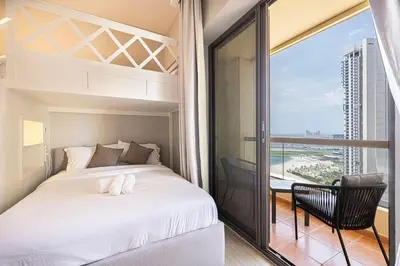 a bedroom with a bed and a balcony at FIRST CLASS 2BR Breathtaking Beach Views in Dubai