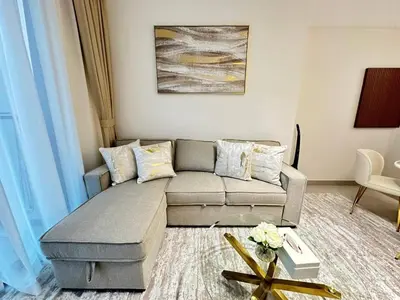 a living room with a couch and a table at Bright 1br Jvc Balcony & Free Parking in Dubai