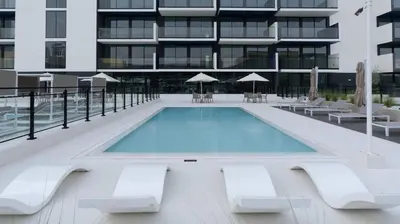 a swimming pool in front of a building at Modern 1br In Jvc Balcony, Pool & Parking in Dubai