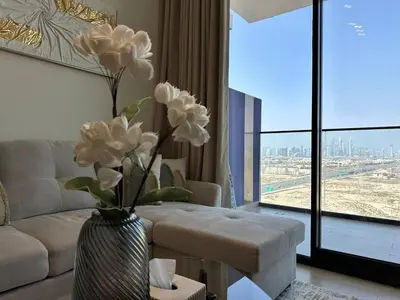 a living room with a vase with white flowers in it at Modern 1br In Jvc Balcony, Pool & Parking in Dubai