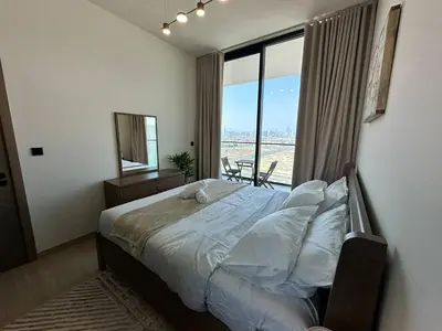 a bedroom with a bed and a large window at Modern 1br In Jvc Balcony, Pool & Parking in Dubai