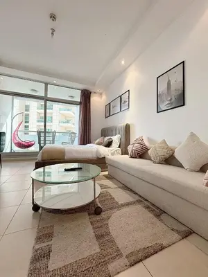 a living room with a couch and a glass table at Chic Studio in Dubai Marina in Dubai