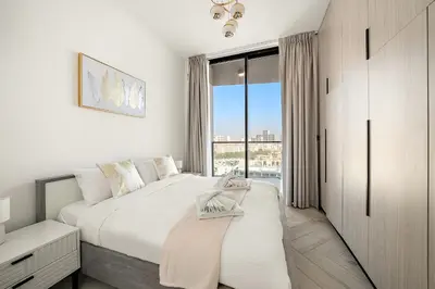 a white bedroom with a large bed and a window at Elegant 1 BR in Empire Residence in Dubai