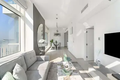 a living room with a couch and a large window at Silkhaus Comfy 1BR in Botanica Tower near Dubai Marina in Dubai