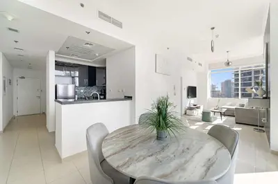 a dining room and living room with a table and chairs at Silkhaus Comfy 1BR in Botanica Tower near Dubai Marina in Dubai