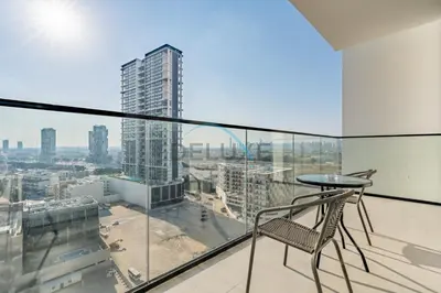 a glass balcony with a chair and a view of a city at Cozy 1BR with Balcony in Binghatti House, Jumeirah Village Circle by Deluxe Holiday Homes in Dubai