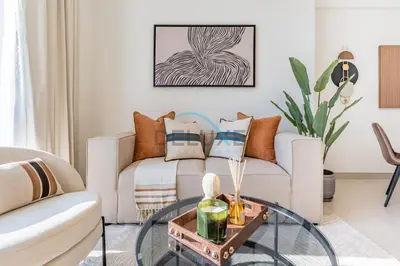 a living room with a couch and a glass table at Cozy 1BR with Balcony in Binghatti House, Jumeirah Village Circle by Deluxe Holiday Homes in Dubai