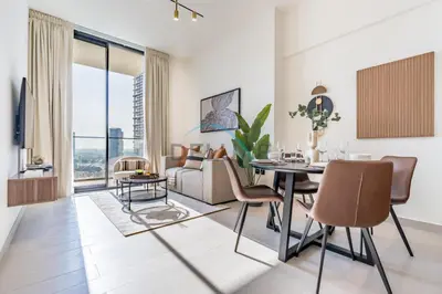a living room with a table and a couch at Cozy 1BR with Balcony in Binghatti House, Jumeirah Village Circle by Deluxe Holiday Homes in Dubai