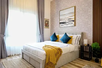a bedroom with a bed with blue and yellow pillows at Modern Studio in Discovery Gardens, Close to Metro in Dubai