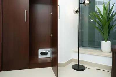 a bathroom with a shower with a clock and a plant at King 1BR Apartment With Burj Khalifa & Fountain View in Dubai