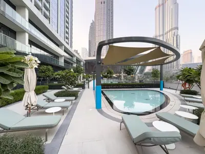 a swimming pool on the roof of a building with lounge chairs at EMAAR GRANDE - Elegant 1 Bedroom Apartment - Infinity Pool - 1min to Dubai Mall and Burj Khalifa in Dubai