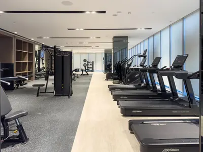 a row of treadmills in a gym with machines at EMAAR GRANDE - Elegant 1 Bedroom Apartment - Infinity Pool - 1min to Dubai Mall and Burj Khalifa in Dubai