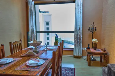 a dining room with a table and a large window at ROYAL BEACH RESiDENCES 1 in Dubai