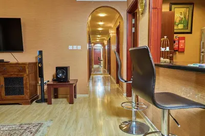 a hallway with a bar with a chair and a television at ROYAL BEACH RESiDENCES 1 in Dubai