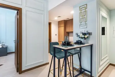 a kitchen with a small table and two stools at The Smart Concierge - Urban Oasis by Missoni in Dubai