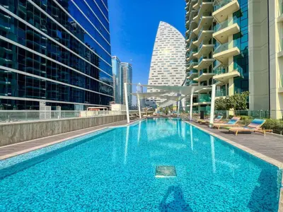 a swimming pool in the middle of a city with buildings at The Smart Concierge - Urban Oasis by Missoni in Dubai