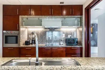 a kitchen with wooden cabinets and a sink at The Smart Concierge - Southridge 1 in Dubai