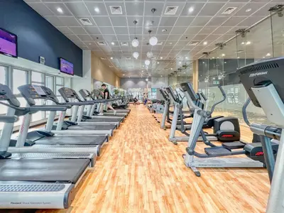 a gym with a row of treadmills and ellipticals at The Smart Concierge - Princess tower in Dubai