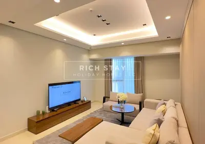 a living room with a couch and a tv at Sleek 2BR in Nobles, Business Bay in Dubai