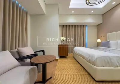 a bedroom with a bed and a couch and a table at Sleek 2BR in Nobles, Business Bay in Dubai