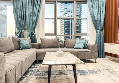 a living room with a couch and a table at DreamShoma -2BR Deluxe Downtown Skyview in Dubai