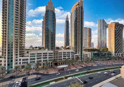 a city with tall buildings and a street with cars at DreamShoma -2BR Deluxe Downtown Skyview in Dubai