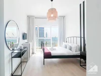 a bedroom with a bed and a large window at Stunning 1B With Balcony & City Views - Dubai in Dubai