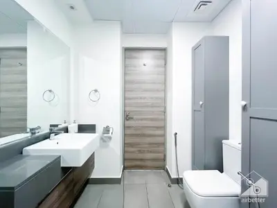 a white bathroom with a sink and a toilet at Stunning 1B With Balcony & City Views - Dubai in Dubai