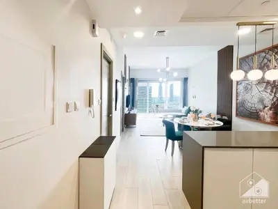 a kitchen and living room with a table and a dining room at Stunning 1B With Balcony & City Views - Dubai in Dubai
