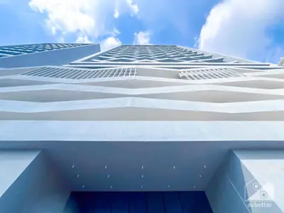 a tall white building with a blue sky in the background at Stunning 1B With Balcony & City Views - Dubai in Dubai