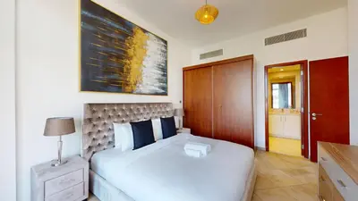 a bedroom with a large white bed and a wooden door at Widcombe House - Tranquil One Bed in Motor City in Dubai