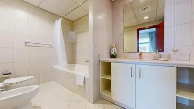 a bathroom with a toilet and a sink and a tub at Widcombe House - Tranquil One Bed in Motor City in Dubai