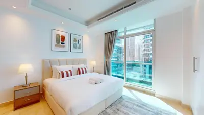 a bedroom with a white bed and a large window at Orra Tower - Stunning One Bed with Marina View in Dubai