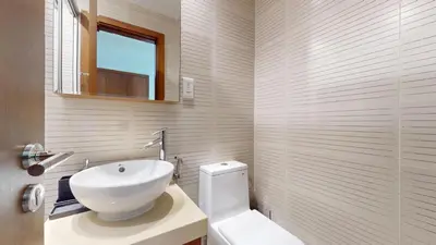 a bathroom with a white toilet and a sink at Orra Tower - Stunning One Bed with Marina View in Dubai