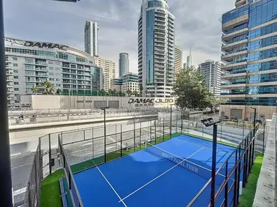 a tennis court in the middle of a city at Orra Tower - Stunning One Bed with Marina View in Dubai