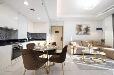 a kitchen and living room with a table and chairs at Famous Infinity Pool 64th floor near Burj Khalifa in Dubai