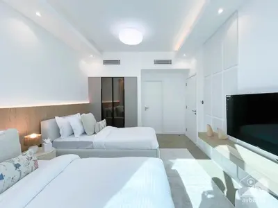 a bedroom with two beds and a flat screen tv at Spacious 2B Apt with Full Marina Views - Delphine in Dubai