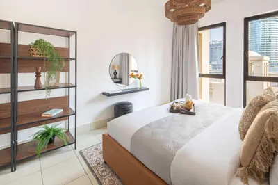 a bedroom with a bed with a mirror and a window at Frank Porter - Reehan 7 in Dubai