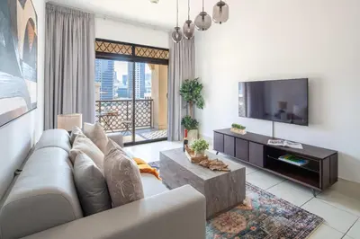 a living room with a couch and a tv at Frank Porter - Reehan 7 in Dubai