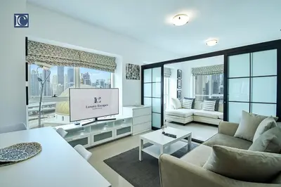 a living room with a couch and a flat screen tv at Cozy 1-Bedroom Apartment in N2 Lakepoint Tower JLT in Dubai