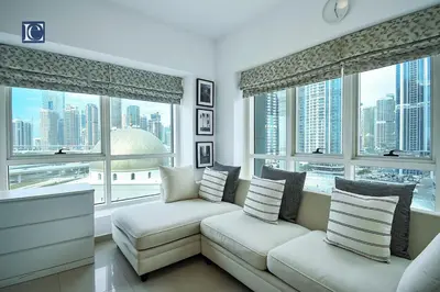 a living room with a couch and large windows at Cozy 1-Bedroom Apartment in N2 Lakepoint Tower JLT in Dubai