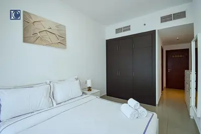 a bedroom with a white bed with two towels on it at Cozy 1-Bedroom Apartment in N2 Lakepoint Tower JLT in Dubai
